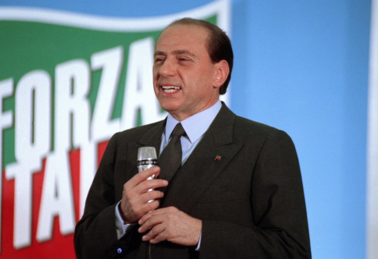 Silvio Berlusconi, in front of the Forza Italia banner