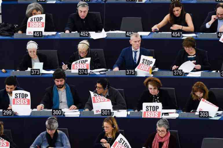Some members of the European parliament protest against the trade and investment agreement known as the "investor-state dispute settlement" (ISDS), which creates a "corporate court" allowing multinational corporations from a trade partner country to sue a government in a tribunal for any law or regulation they regard as unfair.[Frederick Florin/Pool via Getty]