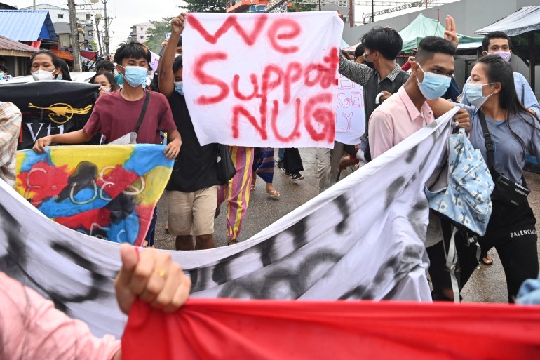 Manifestantes seguram uma bandeira em apoio ao Governo de Unidade Nacional (NUG) enquanto participam de uma manifestação contra o golpe militar em Yangon em 7 de julho de 2021 [File: AFP]