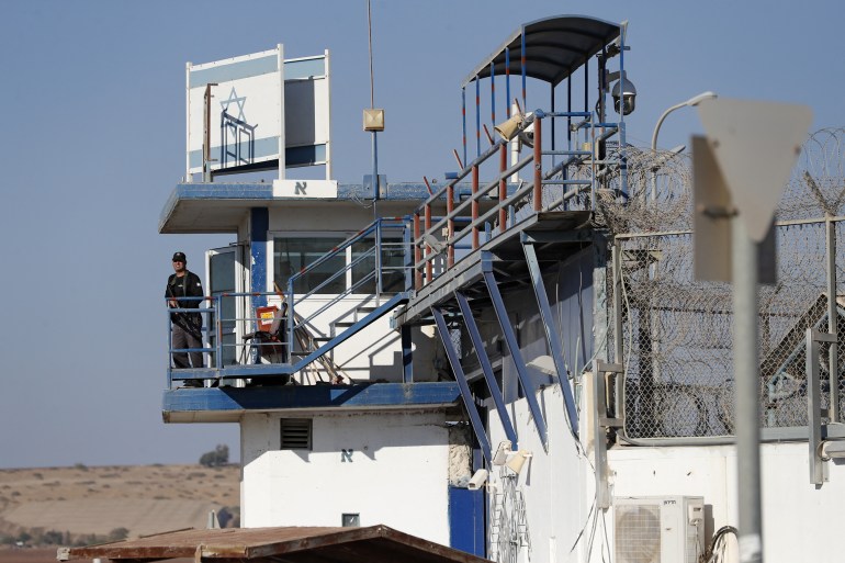 Um membro das forças de segurança israelenses monta guarda na prisão de Gilboa, no norte de Israel [Ahmad Gharabli/AFP]