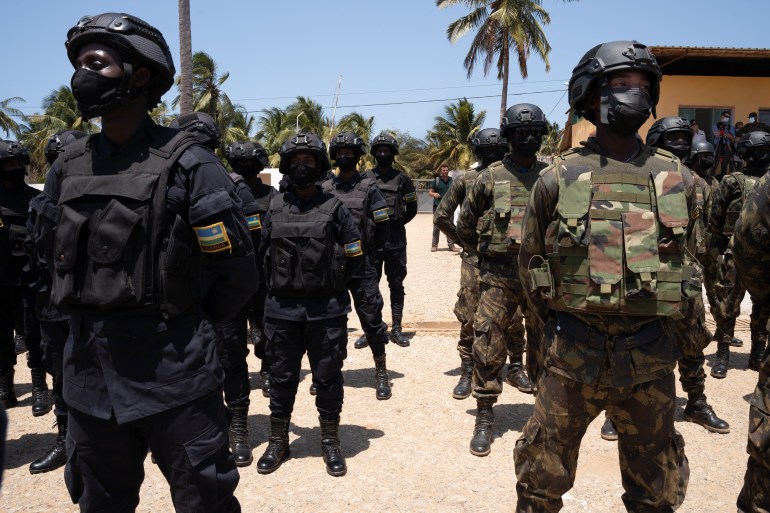 Mozambican soldiers (R in green) and Rwanda policemen (L in blue) stand in the Cabo Delgado province of Mozambique