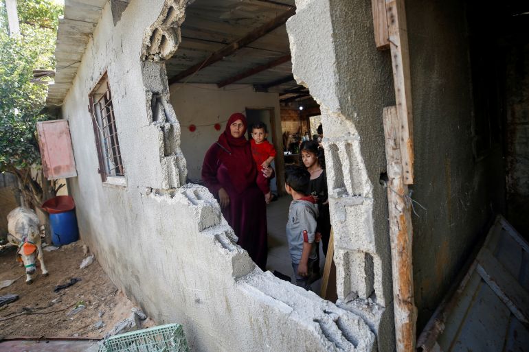 A Palestinian woman looks out of her house damaged in an Israeli bombing in Beit Hanoun in the northern Gaza Strip