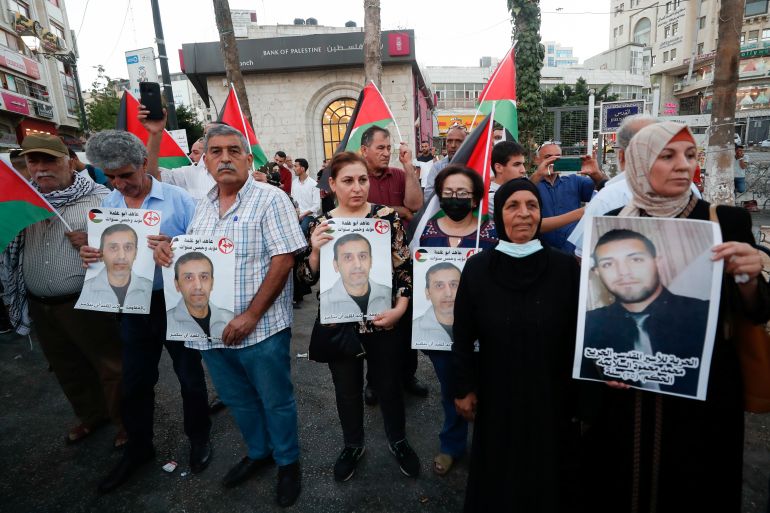 Relatives of Palestinian prisoners in Israeli jails hold their pictures during a protest in Ramallah.
