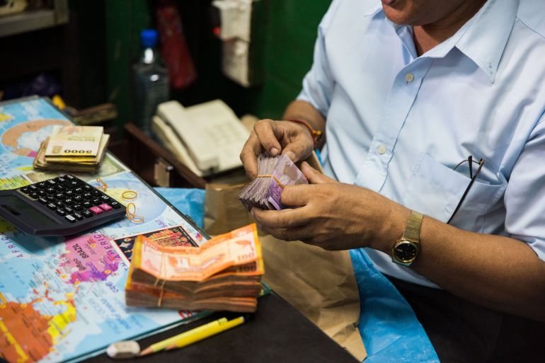A man counts Sri Lankan rupee banknotes