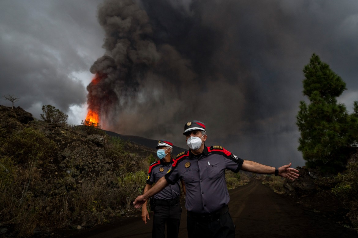 Emergency crews pulled back from the volcano on Friday as explosions sent molten rock and ash over a wide area. [Emilio Morenatti/AP Photo]