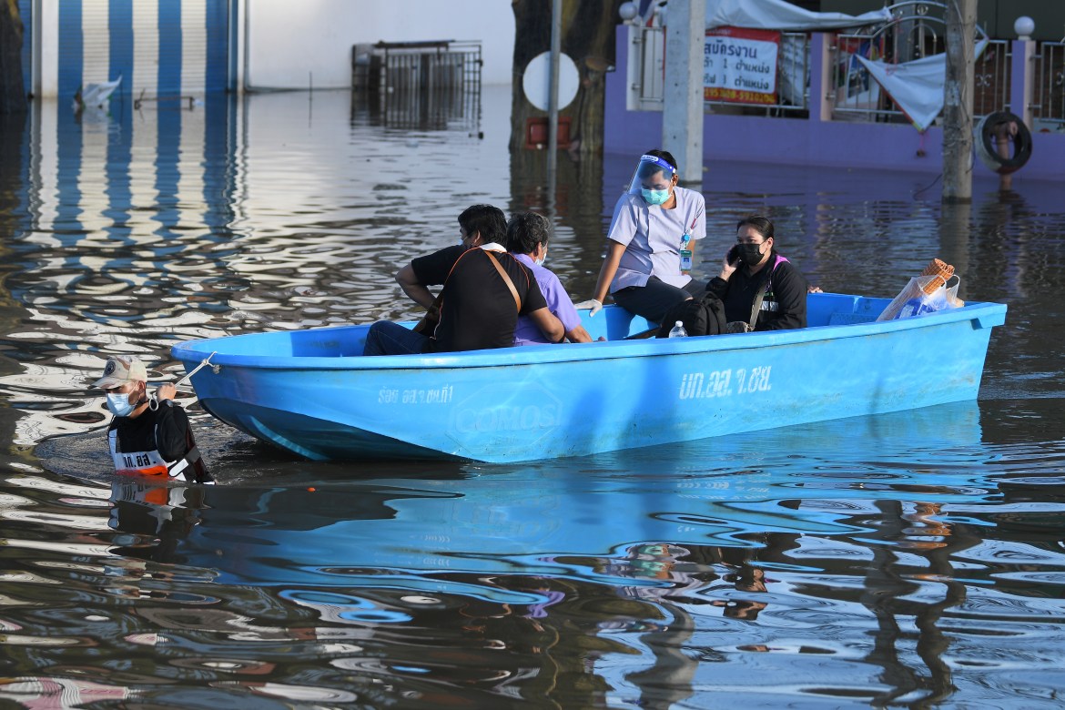 A Thai volunteer pulls a boat carrying evacuees in a flooded area in Chaiyaphum. [Thanachote Thanawikran/AP Photo]