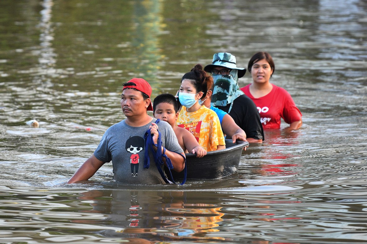 People wade through floodwaters in Chaiyaphum province, northeast of Bangkok, Thailand. [Thanachote Thanawikran/AP Photo]