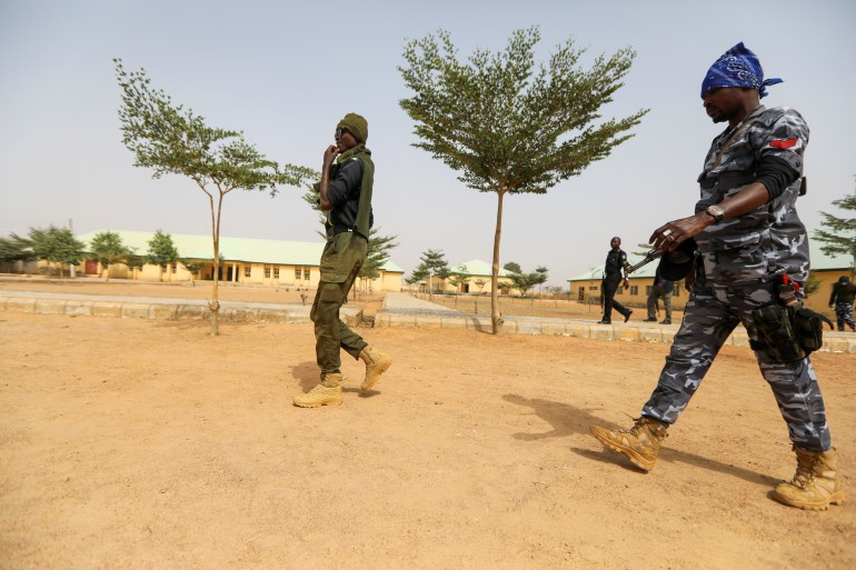 Police officers walk at the JSS Jangebe school, a day after over 300 school girls were abducted by bandits, in Zamfara, Nigeria February 27, 2021.