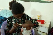 Brkti Gebrehiwot, a 20-year-old woman from Agulae, a town previously occupied by Eritrean troops, tries to feed her one year and eight month old son Aamanuel Merhawi, who suffers from severe acute malnutrition at Wukro hospital in Wukro, Tigray region, Ethiopia, July 11, 2021. [Giulia Paravicini/Reuters]