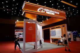 People are seen at a booth of Alibaba Group at an exhibition during the China Internet Conference in Beijing on July 13, 2021 [File: Tingshu Wang/Reuters]