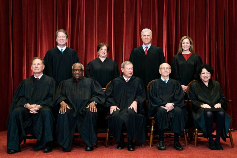 The nine justices of the Supreme Court, dressed in formal black robes, pose for a group photo at the Supreme Court in Washington, DC.
