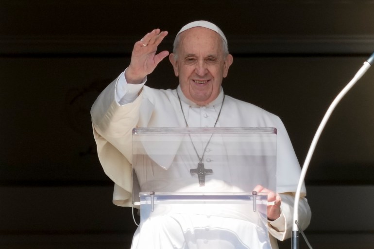 Pope Francis raises his hand to bless the people