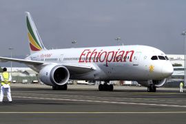 A member of the ground crew directs an Ethiopian Airlines Boeing 787-8 Dreamliner plane