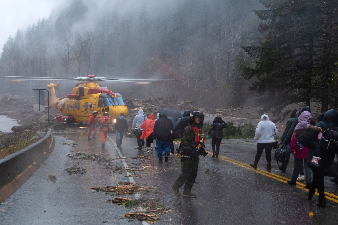Crew members from Royal Canadian Air Force 442 Squadron lead some of over 300 motorists stranded by mudslides towards a CH-149 Cormorant helicopter for their evacuation, in Agassiz, British Columbia, Canada November 15, 2021. Picture taken November 15, 2021. RCAF/Handout via REUTERS MANDATORY CREDIT. THIS IMAGE HAS BEEN SUPPLIED BY A THIRD PARTY.