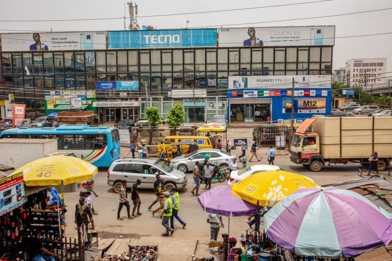 Vehicles and pedestrians walk by the Ikeja computer village market in Lagos, Nigeria, on Monday, March 29, 2021