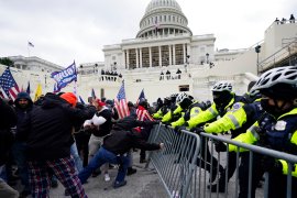 Supporters of former President Donald Trump try to break through a police barrier during the January 6, 2021 attack on the US Capitol. Numerous participants have been charged with federal crimes [File: Julio Cortez/AP Photo]