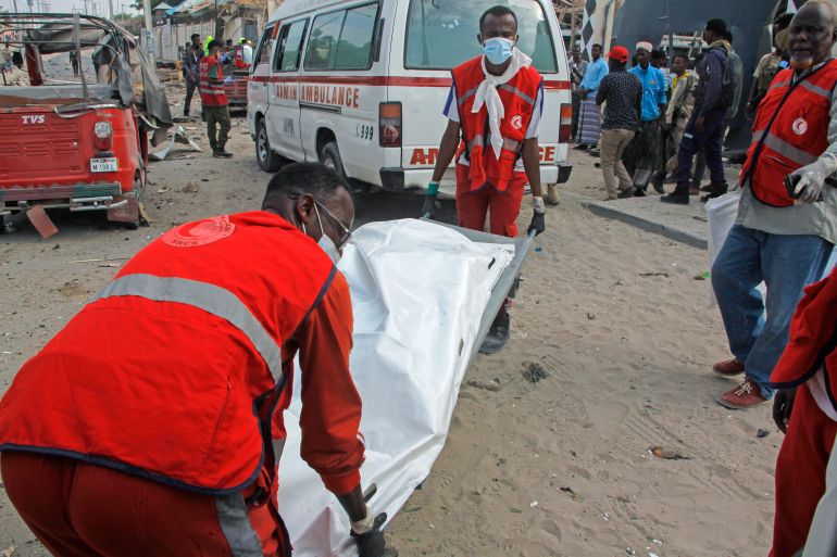 Rescue workers carry away the body of a civilian who was killed in a blast in Mogadishu, Somalia