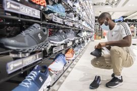 A worker inspects running shoes at a Sports Expertss store on Sainte-Catherine street in Montreal, Quebec, Canada