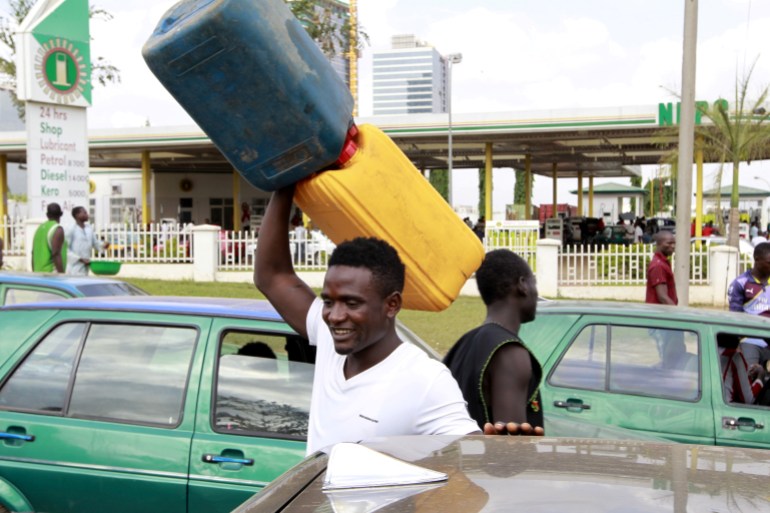 A man carries empty petrol containers in Nigeria