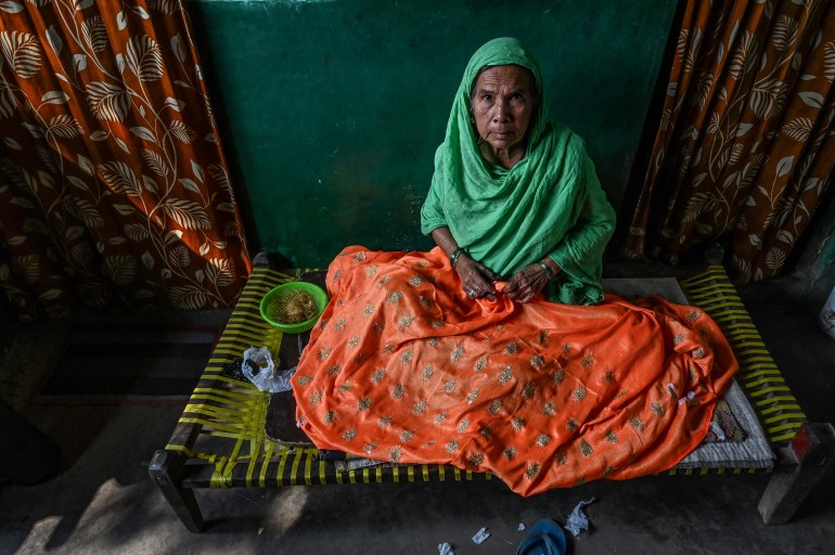 Sultana Begun trabalha em uma peça de roupa dentro de sua casa em Calcutá