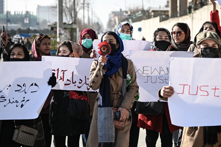 Women hold placards during a protest in Kabul, Afghanistan to demand an end to the extra-judicial killings of former officials