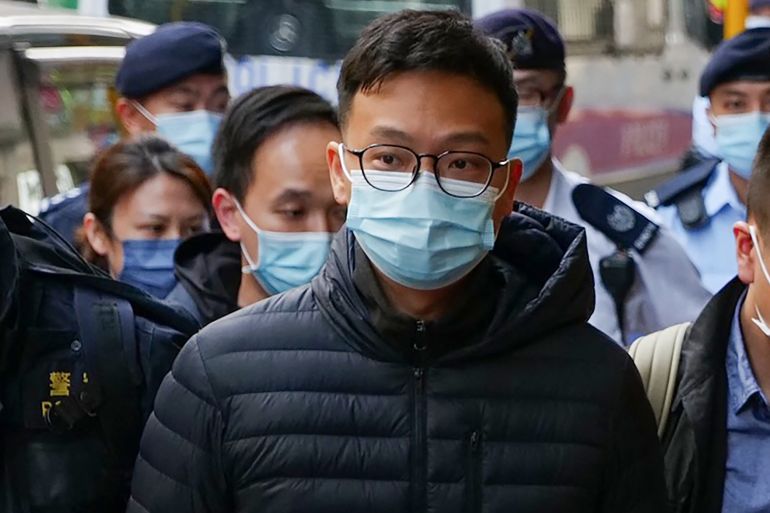Editor Patrick Lam is brought to the news outlet's office building in handcuffs in Hong Kong