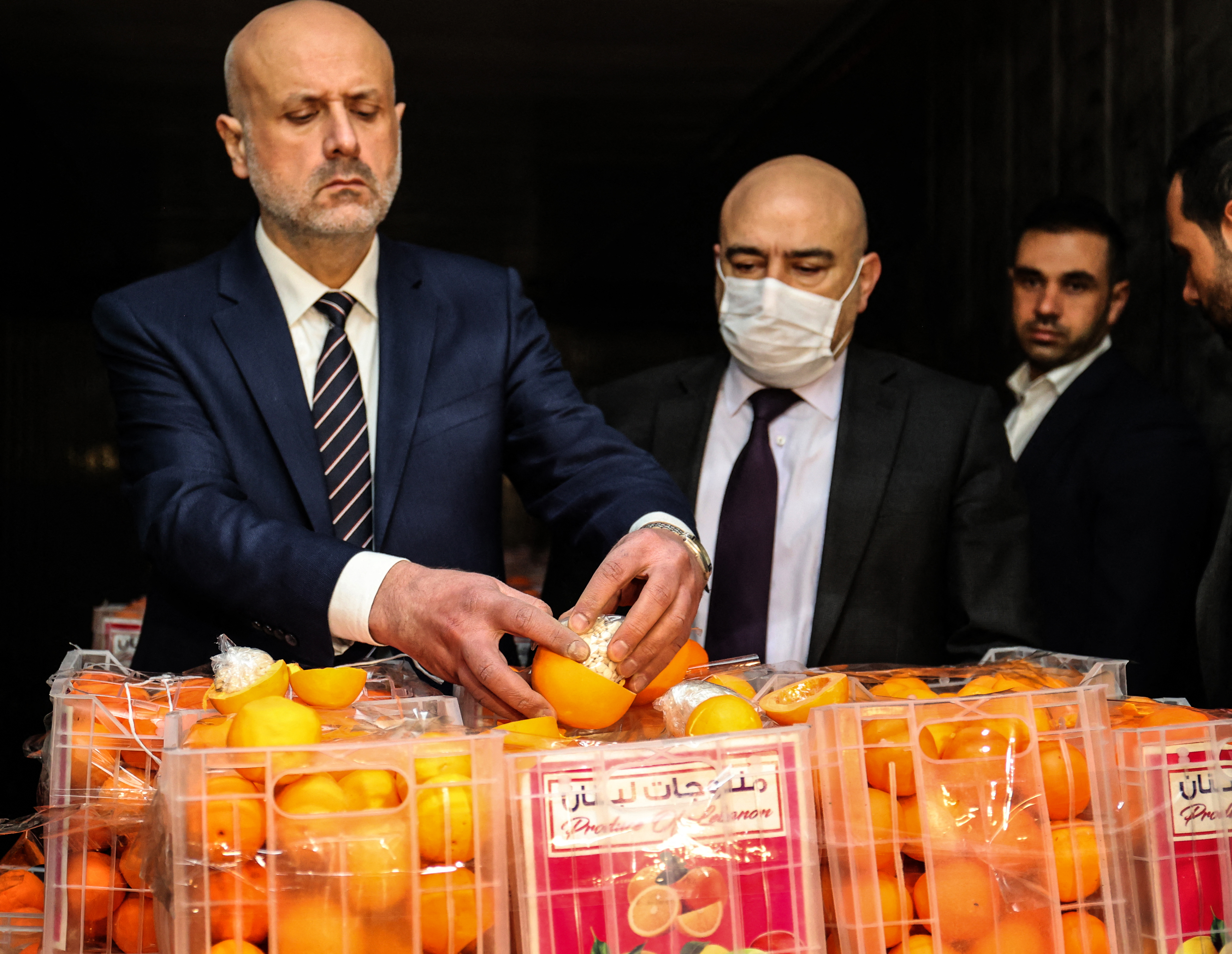 O ministro do Interior do Líbano, Bassan al-Mawlawi, verifica uma das laranjas falsas cheias de comprimidos de Captagon (uma droga ilegal) em caixas contendo frutas reais, depois que o carregamento foi interceptado no porto de Beirute