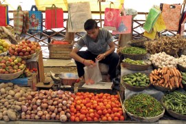 A vendor waits for customers at a vegetable market in Rabangla town