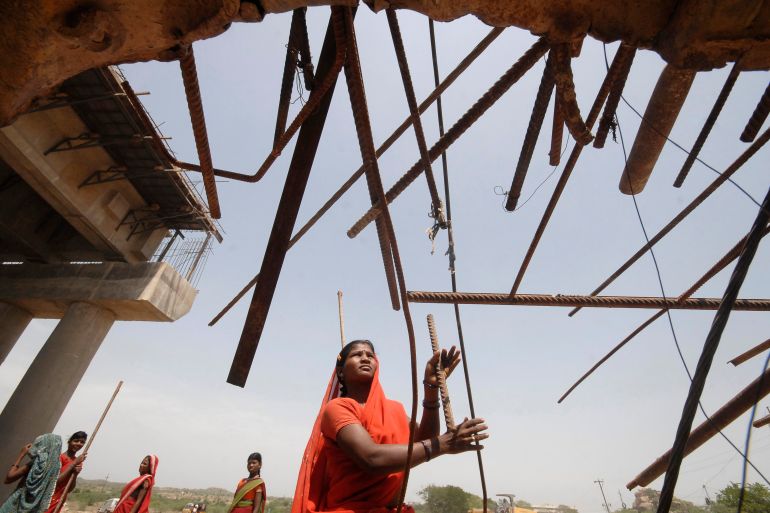 A woman labourer works at a road construction site outside Hyderabad city in India