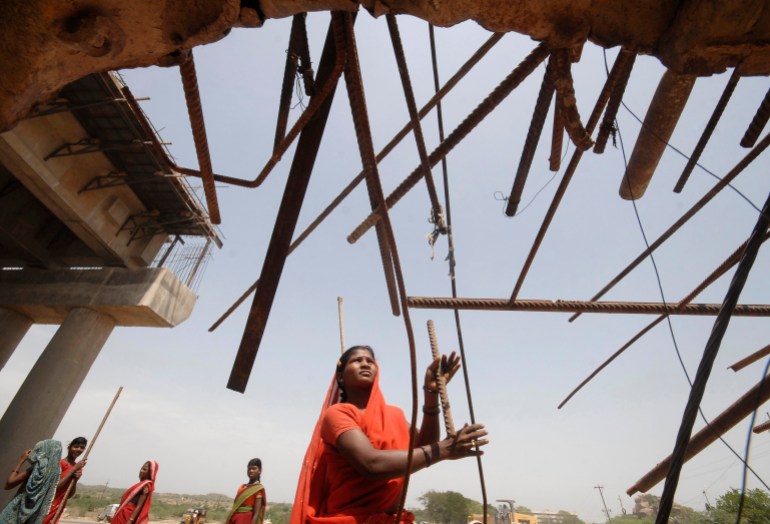 A female laborer works at a road construction site outside Hyderabad city in India