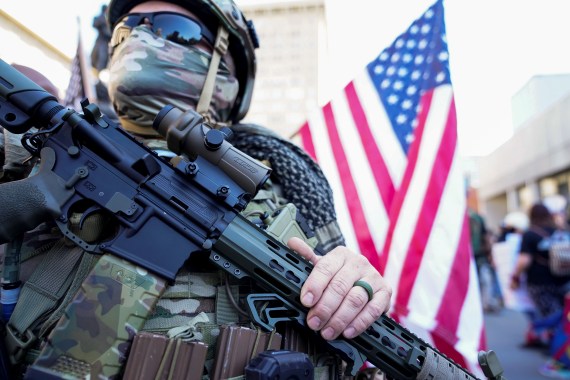 An armed, self-described militia member stands in the street during a rally in Louisville, Kentucky