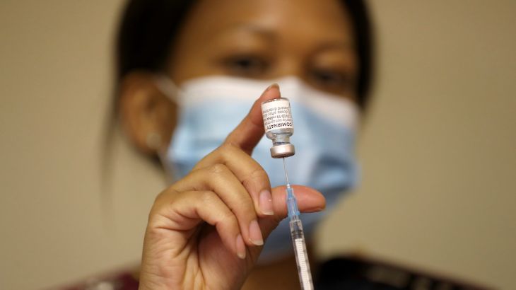 A health worker holds a vial of the Pfizer-BioNTech COVID-19 vaccine