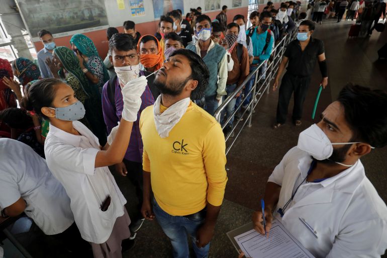 A healthcare worker collects a swab sample from a man in Ahmedabad, India.
