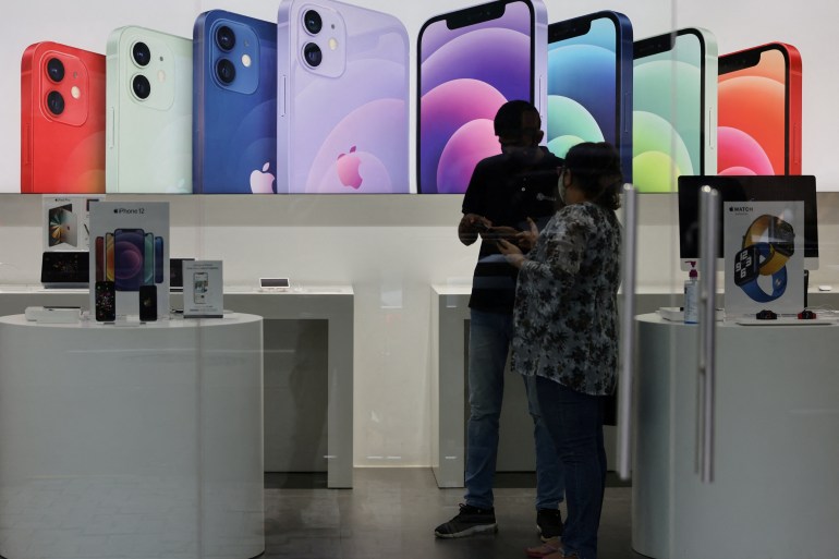 A salesperson speaks to a customer at an Apple reseller store in Mumbai, India