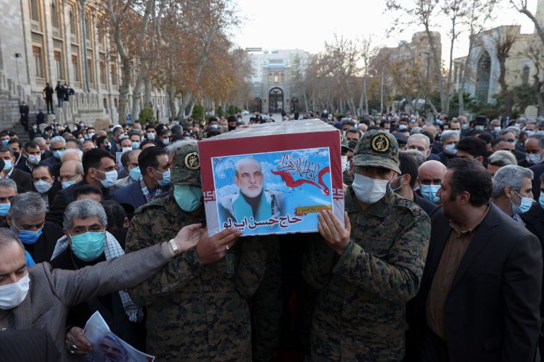 Iranian forces carry the coffin of Iran's ambassador to Yemen, Hasan Irloo, during his funeral