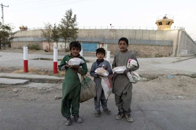 Three children holding food bags