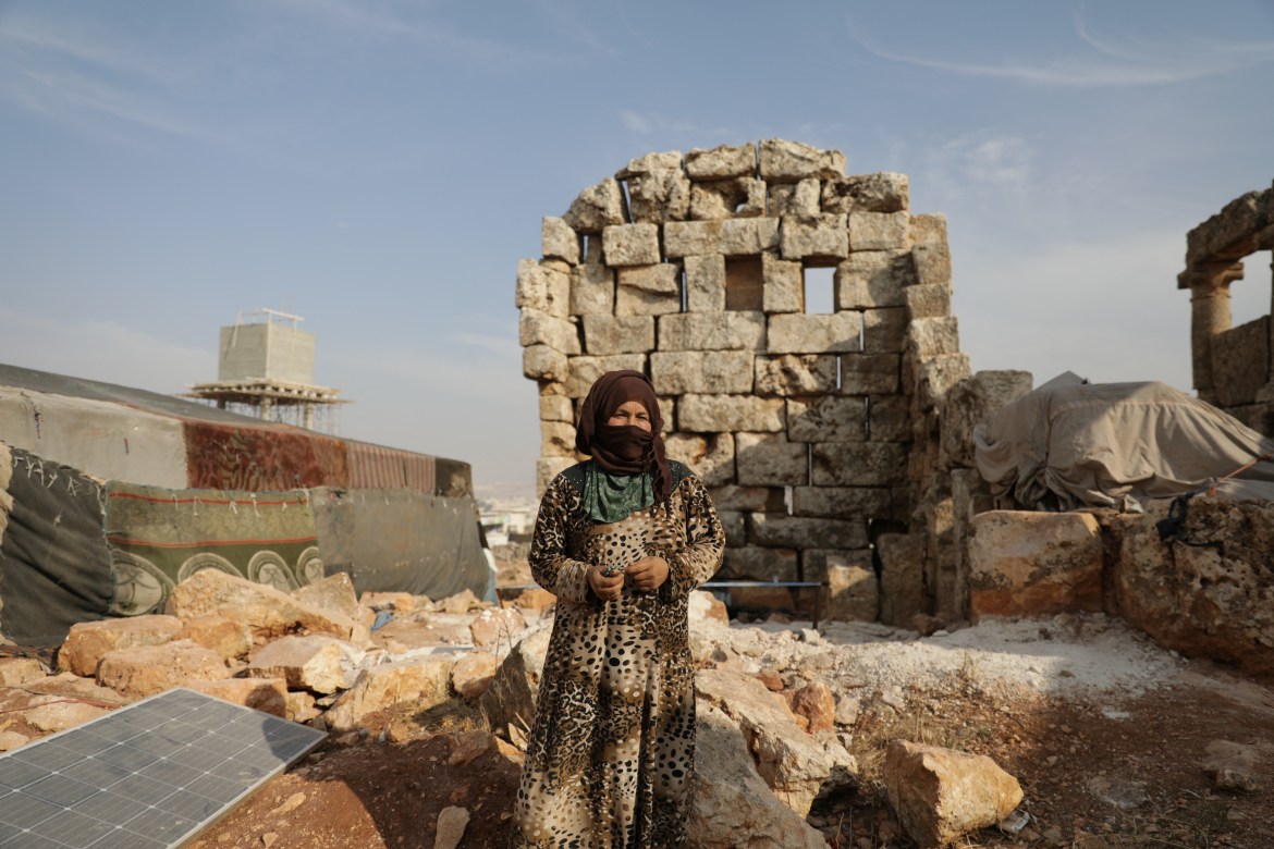 Aida al-Hassan, 44, poses for a photo amongst ruins at the archaeological site of Sarjableh,Syria