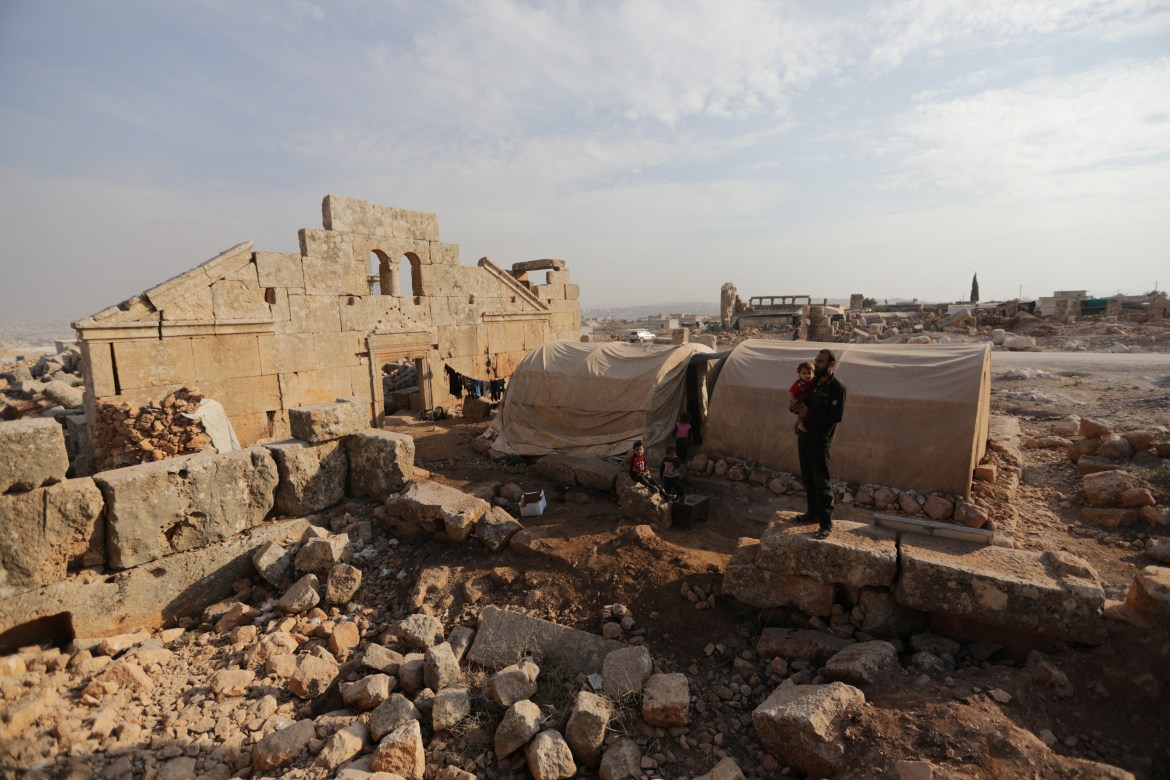 Ο Mohamad Othman, 30 ετών, στέκεται με τα παιδιά του δίπλα στη σκηνή τους στον αρχαιολογικό χώρο Sarjableh της Συρίας