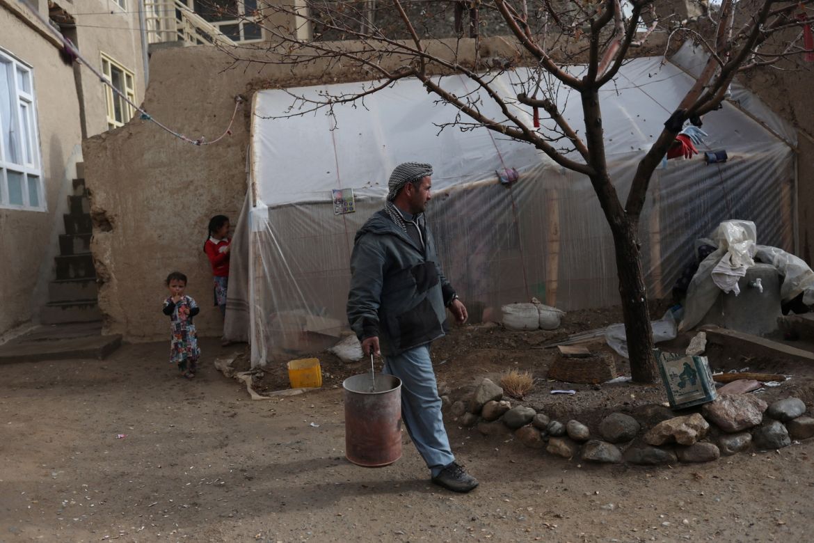 Sayed Yassin Mosawi, carries a bucket to collect coal from his yard in Bamiyan