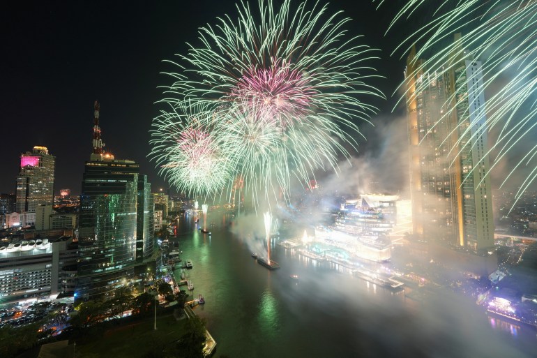 Fireworks explode over the Chao Phraya River during the New Year celebrations in Bangkok, Thailand