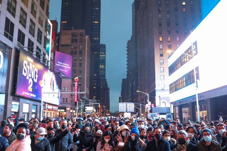 A crowd of people huddles in New York City's Times Square for New Year's celebrations