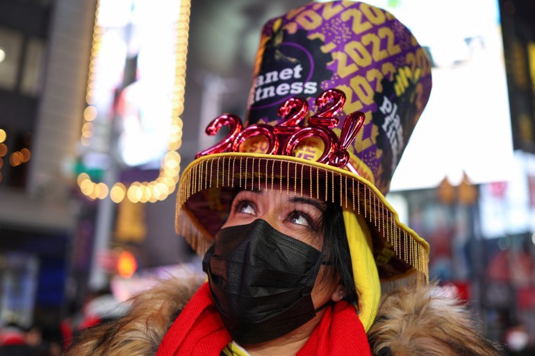 A woman in a tophat stands in New York City's Times Square ahead of the New Year's countdown