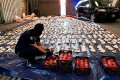 A Saudi custom officer opens imported pomegranates, as customs foiled an attempt to smuggle over 5 million pills of an amphetamine drug known as Captagon from Lebanon