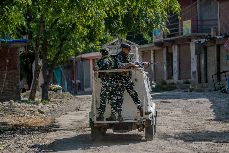 Indian paramilitary soldiers stand guard on an armored vehicle in Indian controlled Kashmir