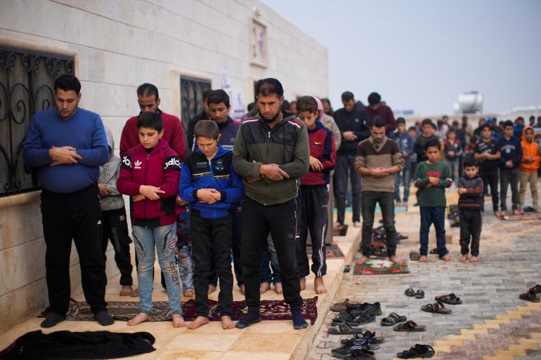 Syrians pray in a refugee camp.