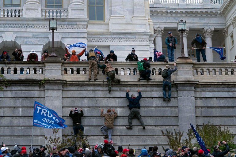 Trump supporters scale a wall at the US Capitol during the January 6 riot