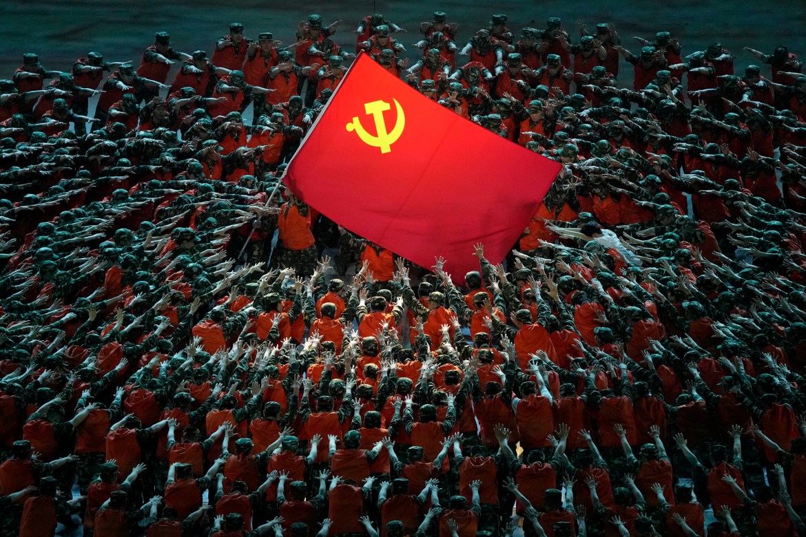 Performers dressed as rescue workers gather around the Communist Party flag during a gala show ahead of the 100th anniversary of the founding of the Chinese Communist Party in Beijing