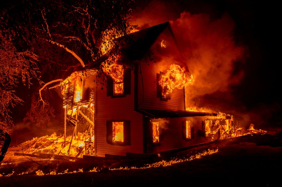 A home is engulfed in flames as the Dixie fire rages south of Janesville in Northern California