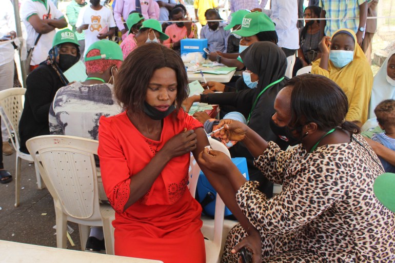 A Nigeria civil servant receives an AstraZeneca coronavirus vaccine, before she is allow access to her office in Abuja, Nigeria