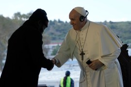 Pope Francis shakes hands with Christian Tango Mukaya, a 30-year-old asylum-seeker from Congo, during a ceremony at the Karatepe refugee camp, on the northeastern Aegean island of Lesbos, Greece